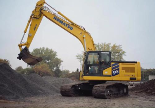 Komatsu PC220LCi-12 excavator working with play button for video